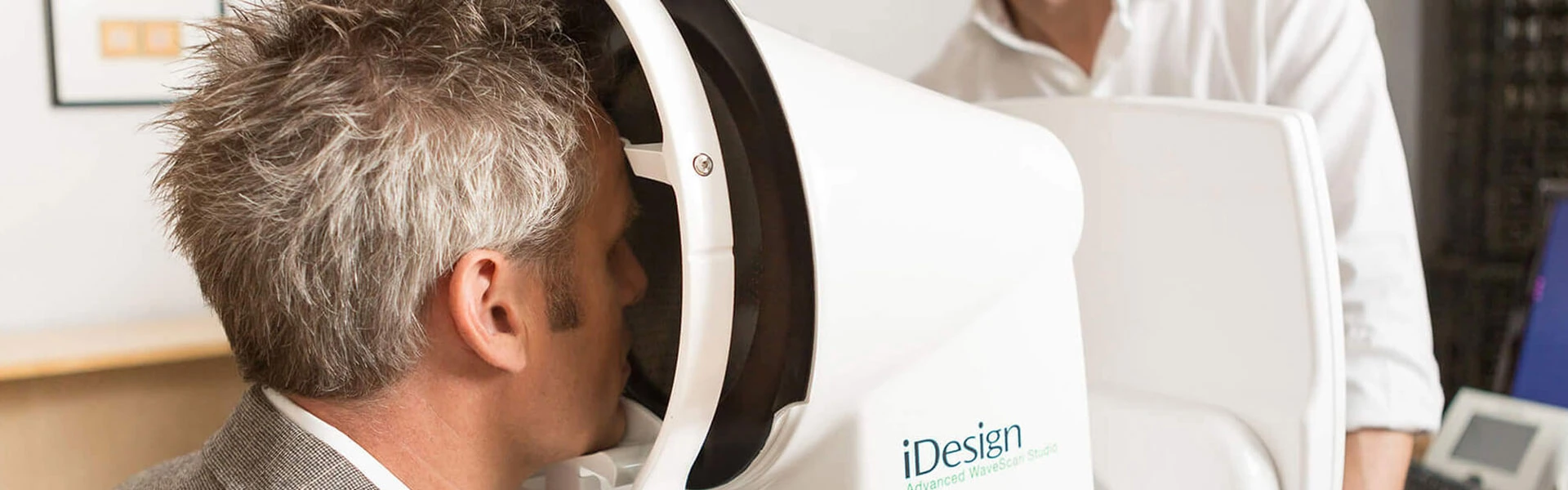 Man receiving an eye exam with an iDesign Advanced WaveScan Studio machine