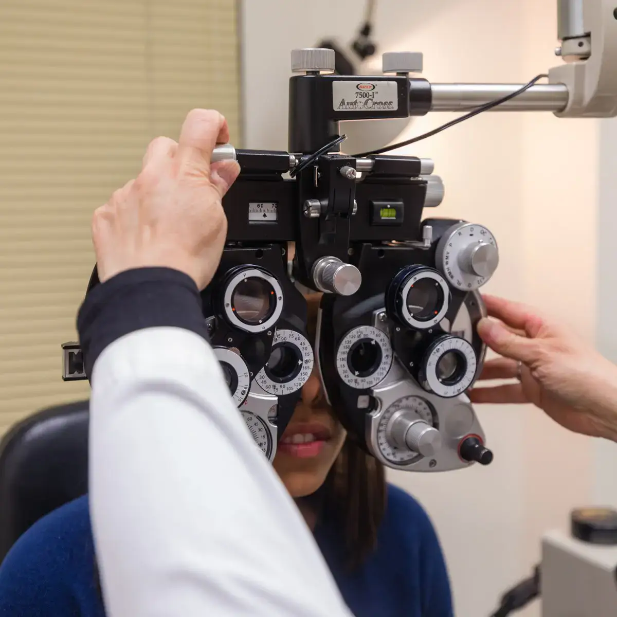 Close-up of an eye exam with a phoropter and patient.