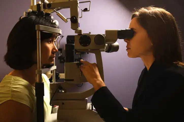 Eye doctor examining a patient's eye with a slit lamp